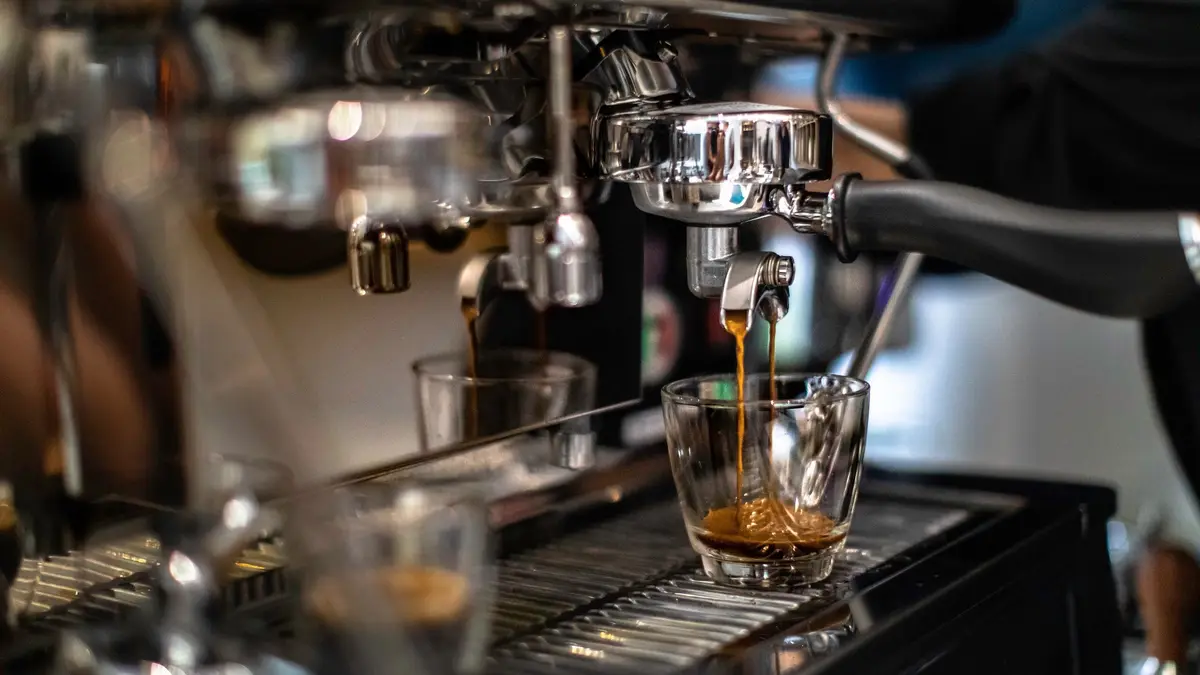 Espresso pouring from a machine into a small glass