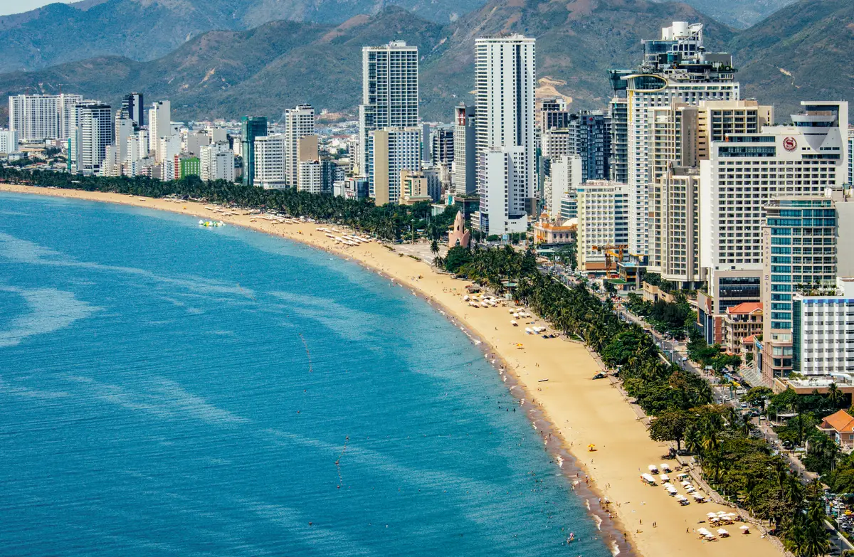 Aerial view of Nha Trang's high-rise hotels along a curved beach with turquoise water
