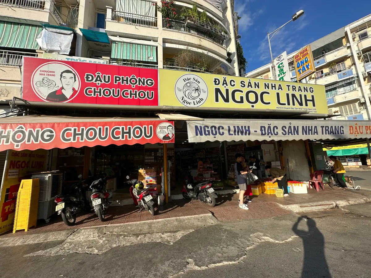 Shopfronts selling Nha Trang specialties with red and yellow signs on the street