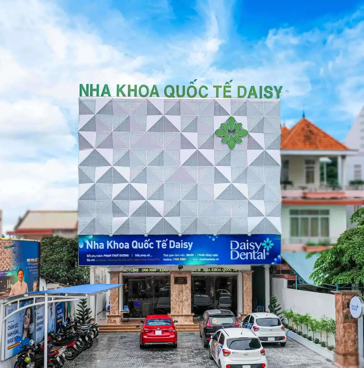 Grey geometric clinic facade with a Nha Khoa Quoc Te DAISY banner