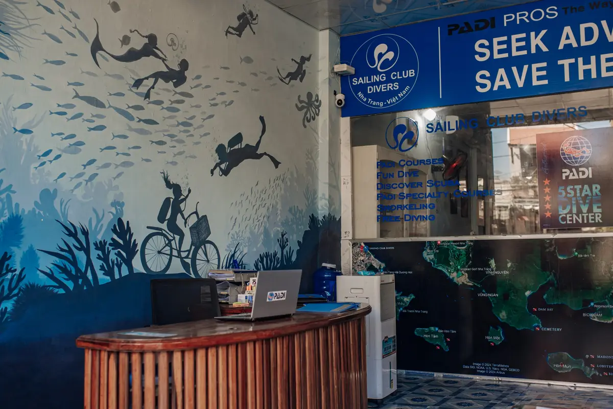Wooden counter and wall mural of divers and fish inside a dive shop