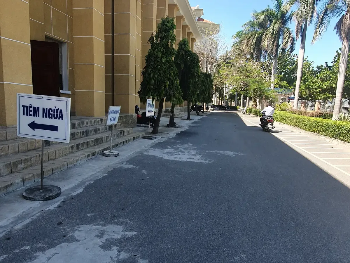 Arrow sign pointing to the vaccination area on a quiet paved lane