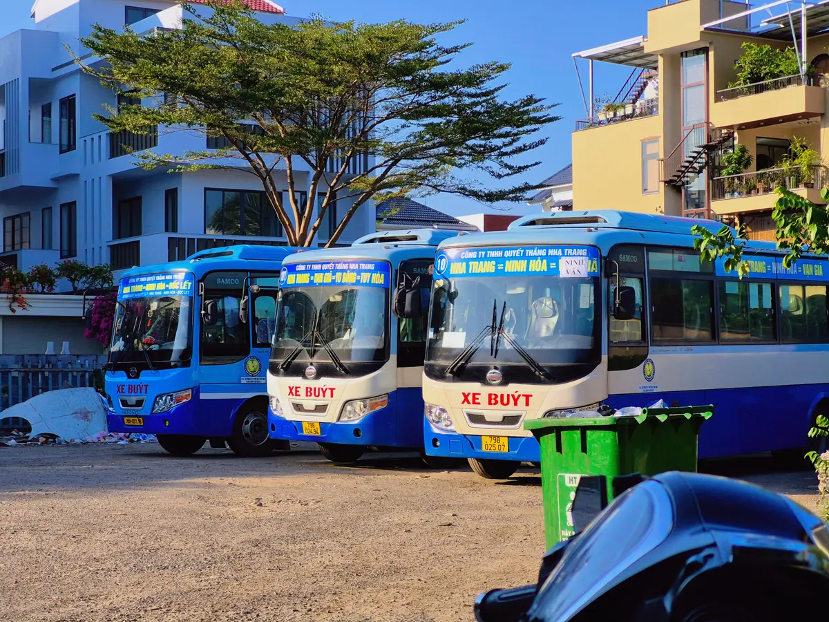 Row of blue and white city buses parked in a yard at the Quyet Thang bus station in Nha Trang