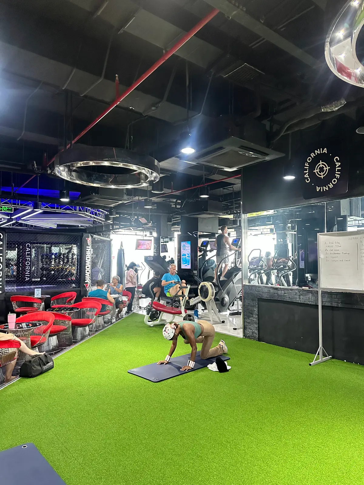 Group exercise area with green turf and red chairs inside California Fitness