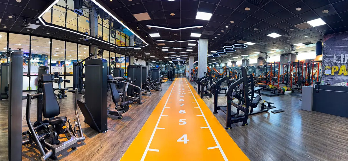 Long gym floor with an orange running track marked with distances