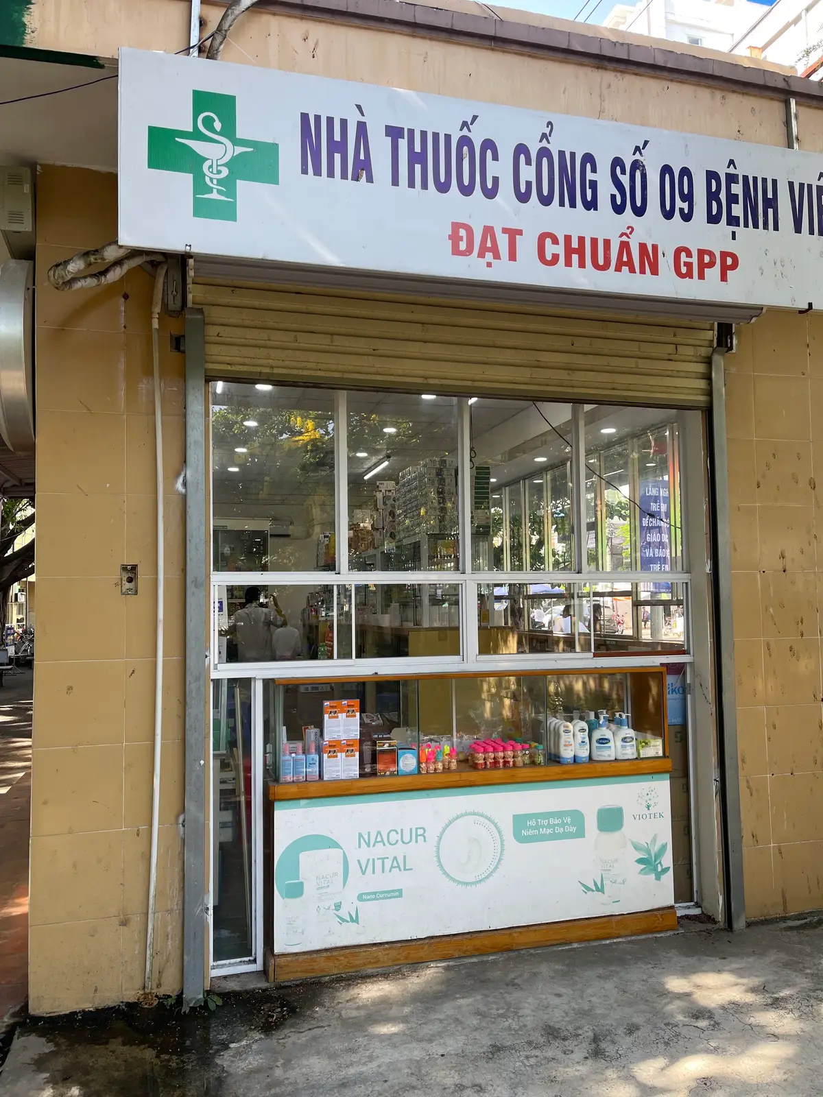 Pharmacy window with shelves of medicine boxes inside a hospital building