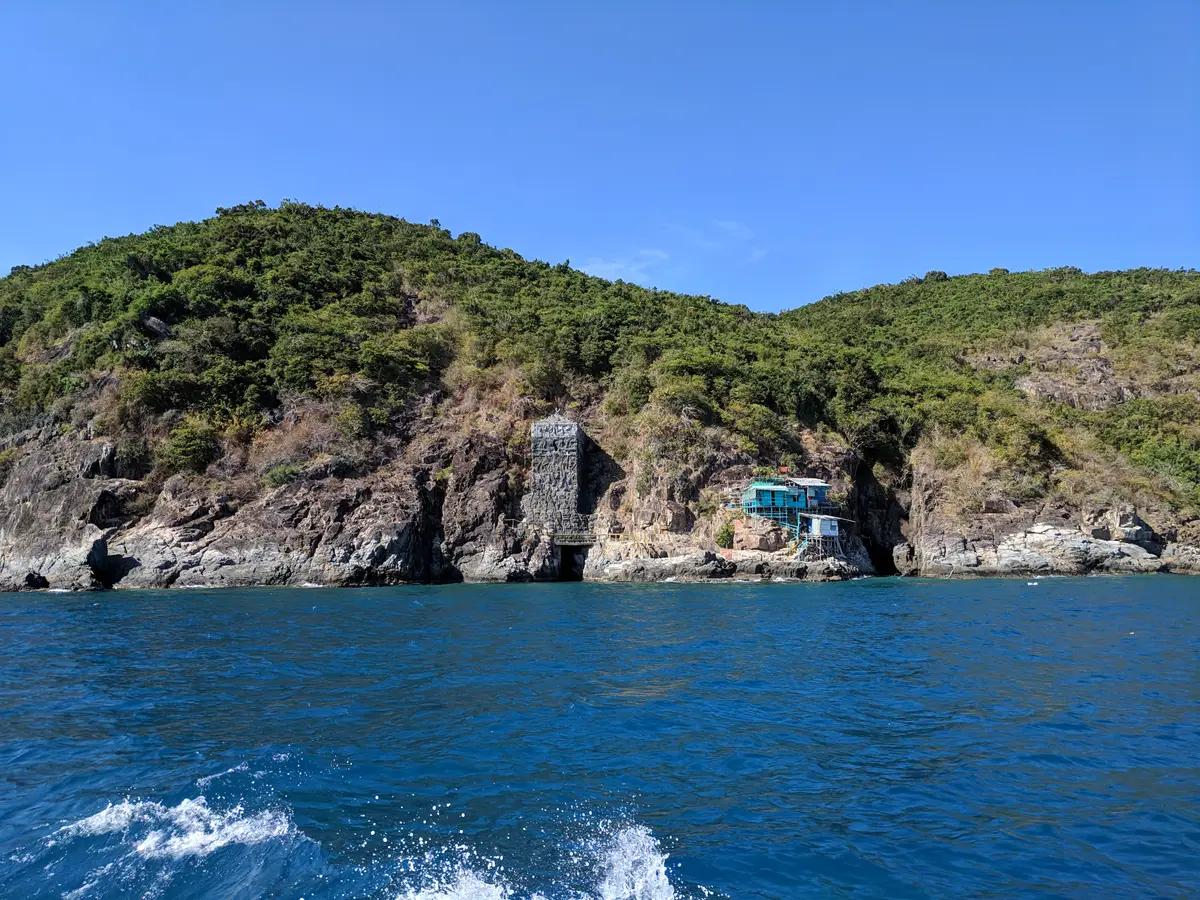 Rocky green island coast seen from the water