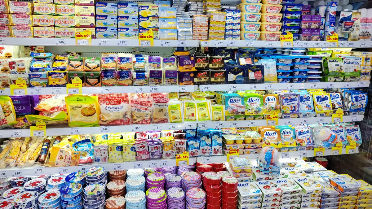 Supermarket shelves of tinned fish, canned goods and packaged snacks in bright colours