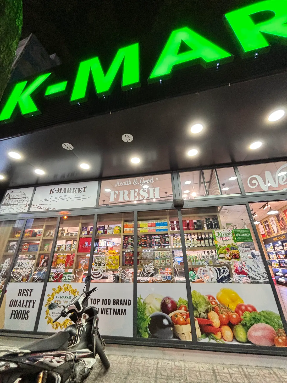 Glass shopfront with a K-Market sign and shelves of packaged goods visible inside