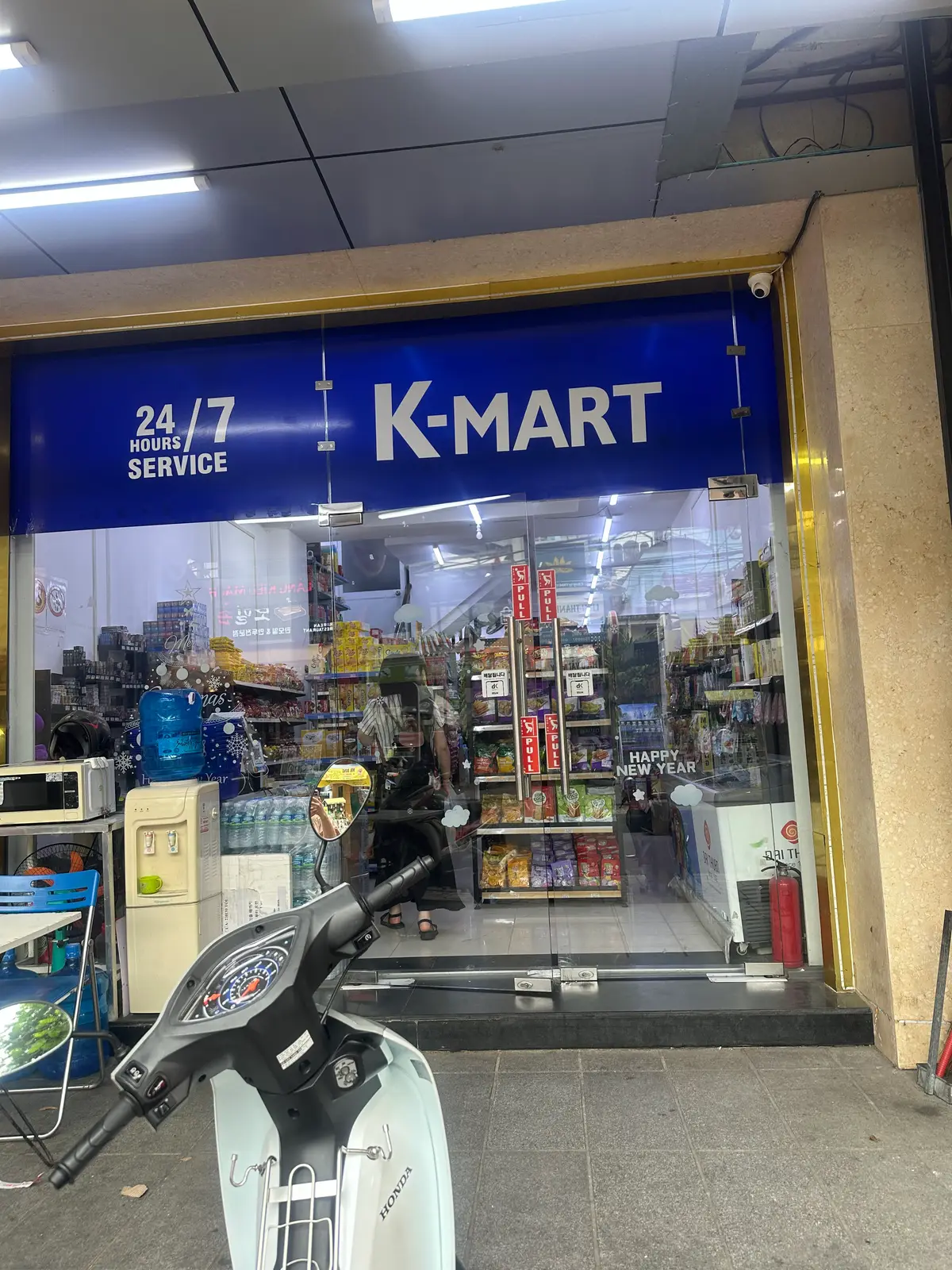 Blue K-Mart sign above a glass shopfront with shelves of goods inside