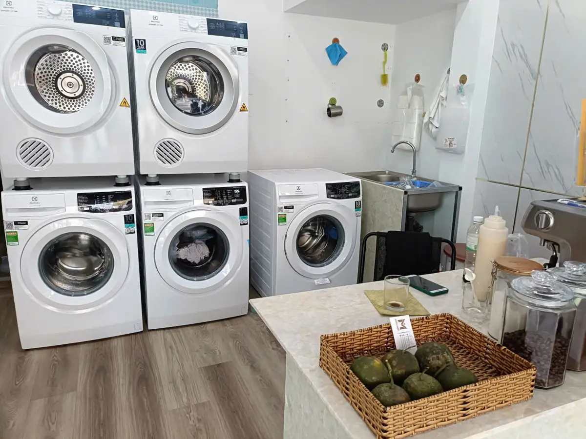 Front-loading washers beside a counter with a basket in a laundry