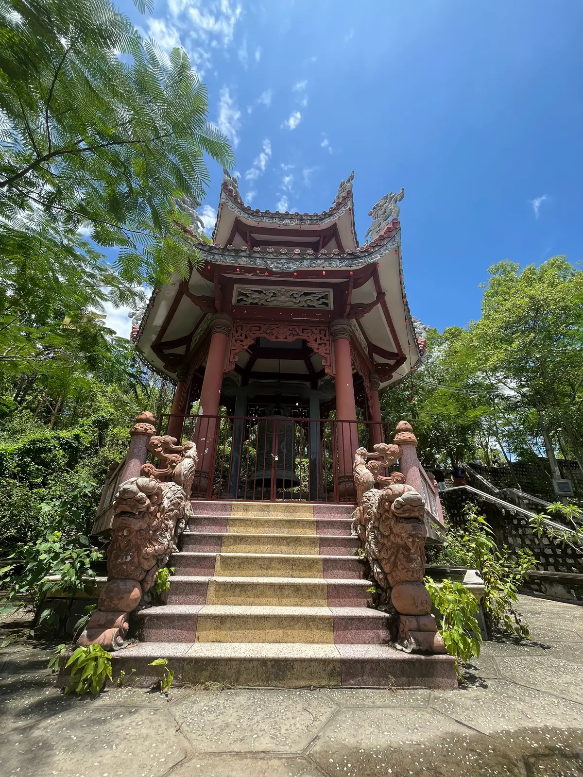 Red wooden pavilion on a stone stair guarded by carved stone dragons