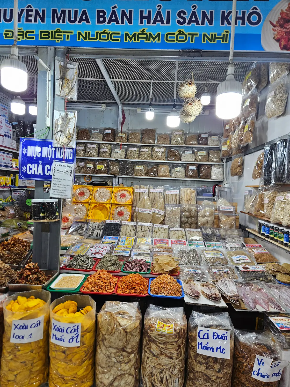 Market stall with dried seafood and snacks in neat piles
