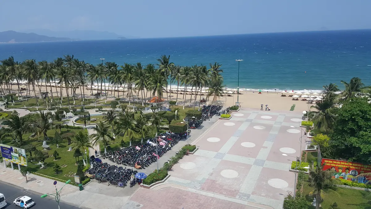 Aerial view of the seafront park and paved square beside Nha Trang beach, with the road and sea beyond