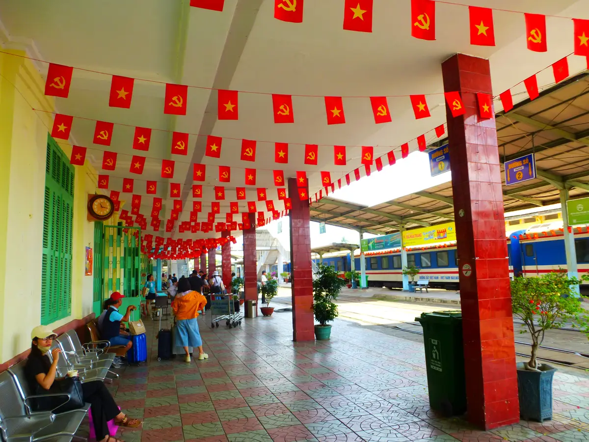 Waiting hall with red pillars, flags overhead and benches