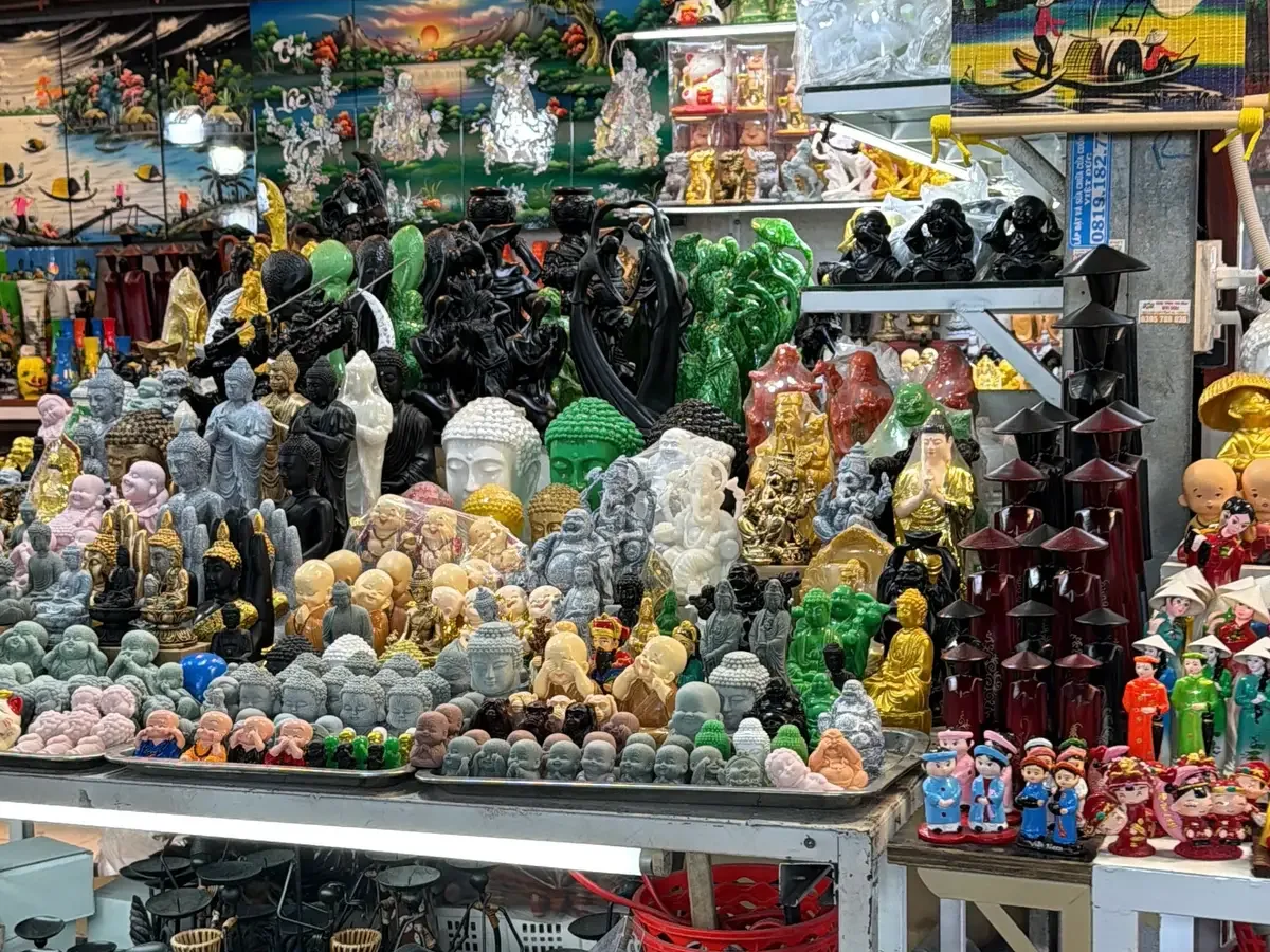 Stall shelves packed with carved stone and wood souvenir figures