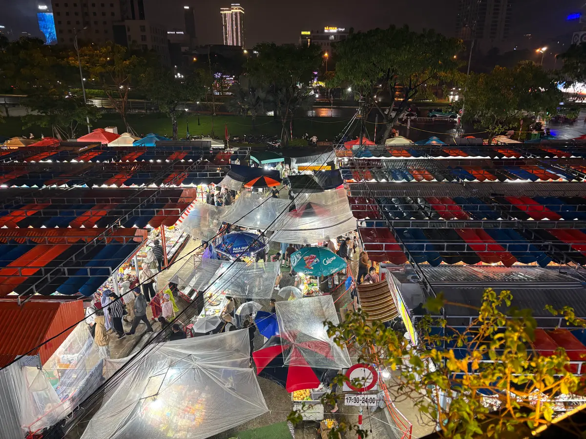 Night view from above of a street market with blue and red stall roofs