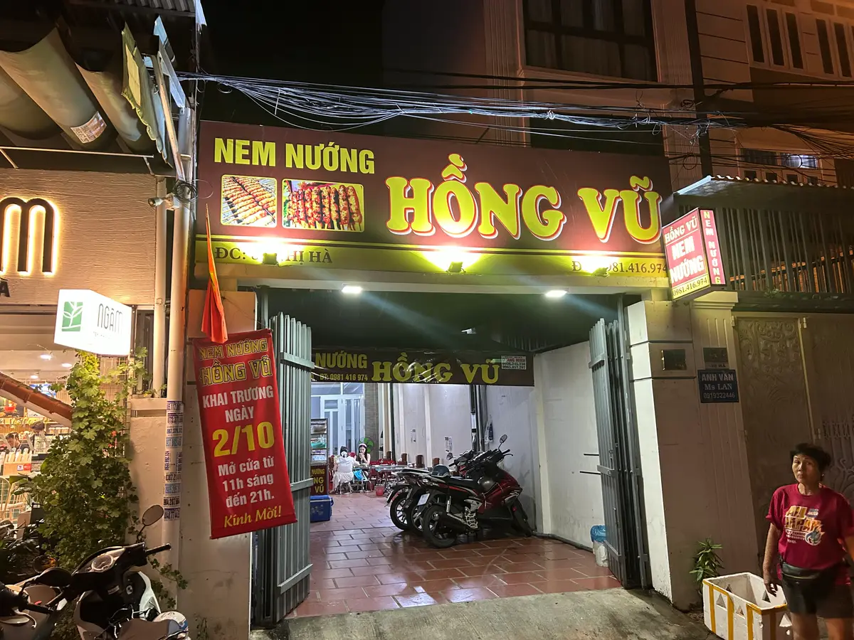 Shopfront with a red and yellow sign at night with scooters parked inside